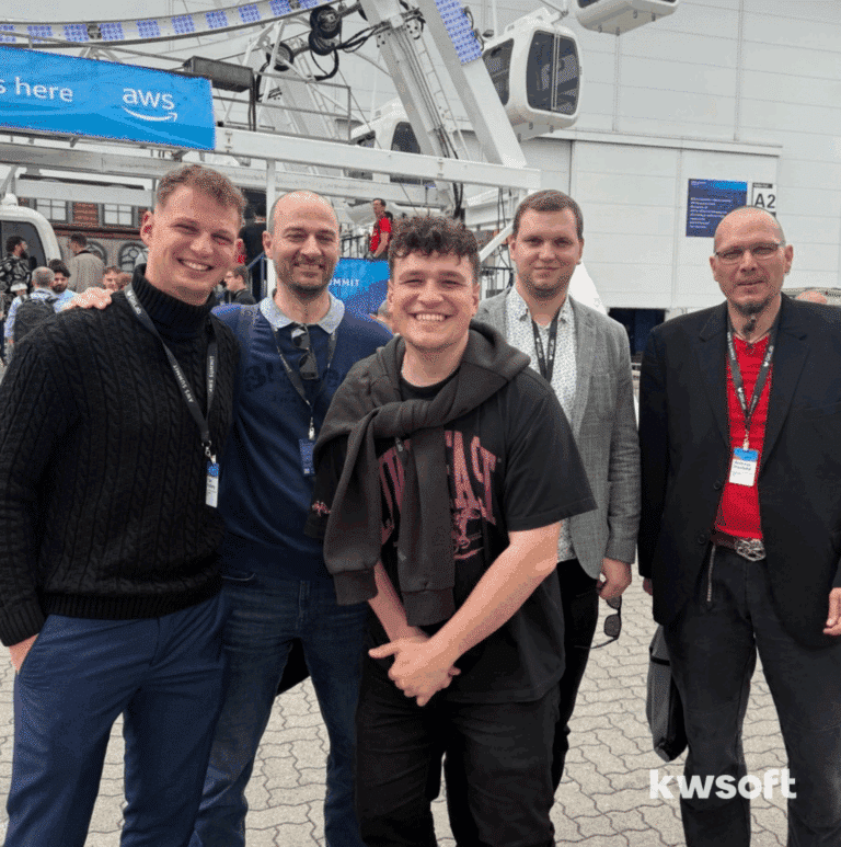 Our kwsoft® team is standing in front of the entrance to the AWS Summit 2025.