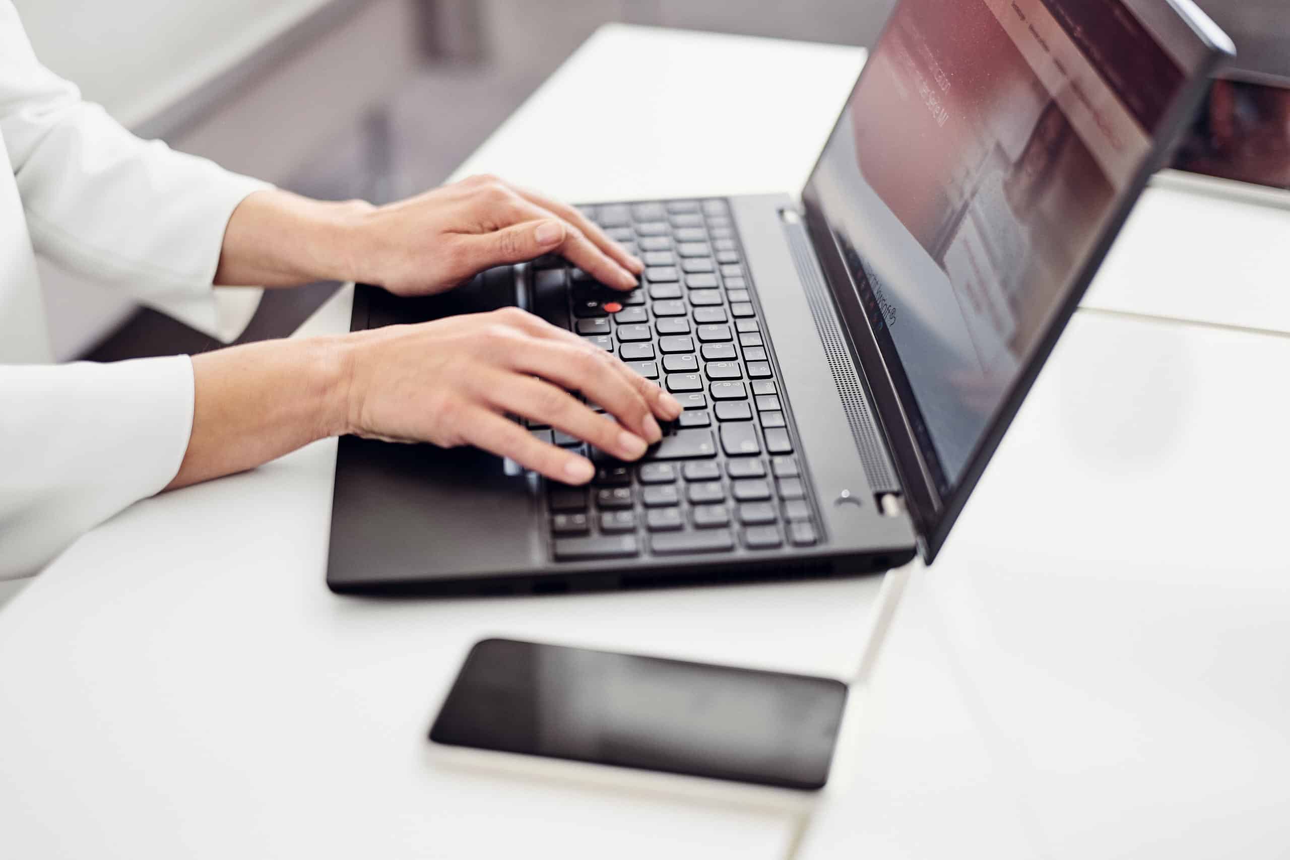 A person is sitting at a laptop and visiting the Kwsoft website.
