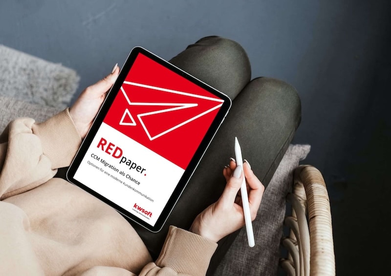 A woman is sitting on a chair with a tablet in her left hand and a pen in the other. The REDpaper from kwsoft on “CCM Migration as an Opportunity” is open on the tablet.