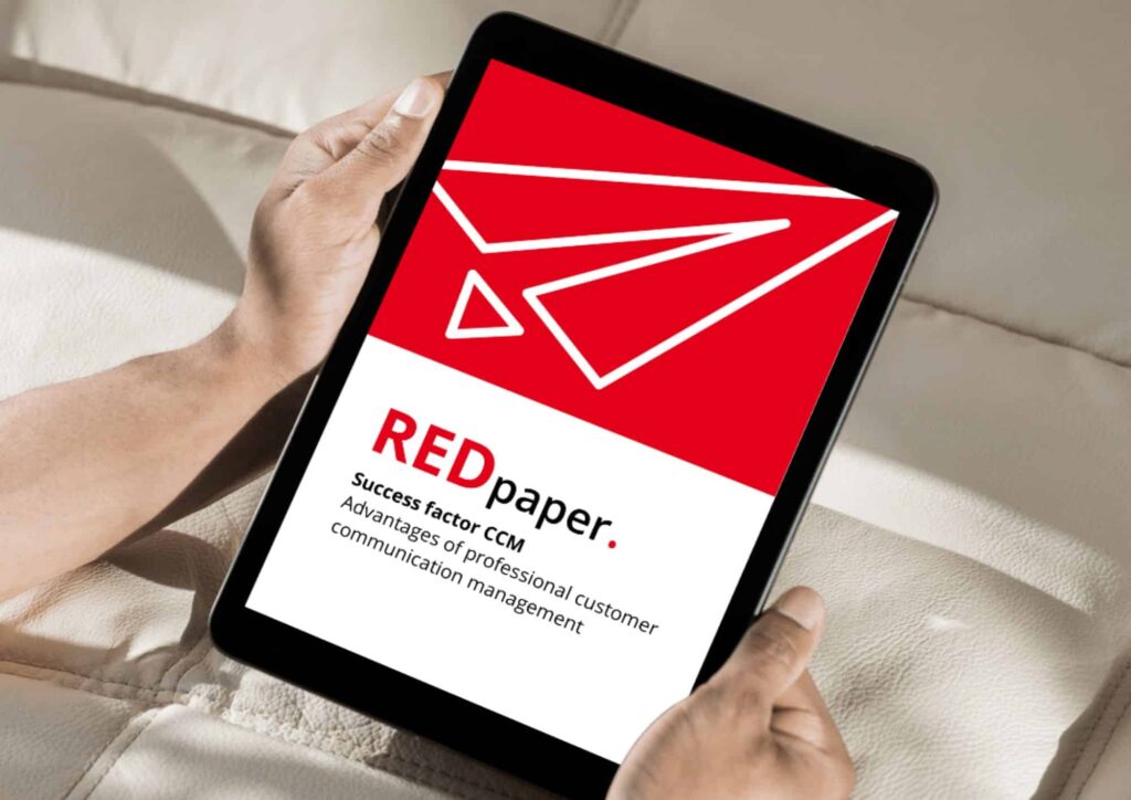 The image shows a tablet hold by someone which shows the cover of the REDpaper "Success Factor CCM"